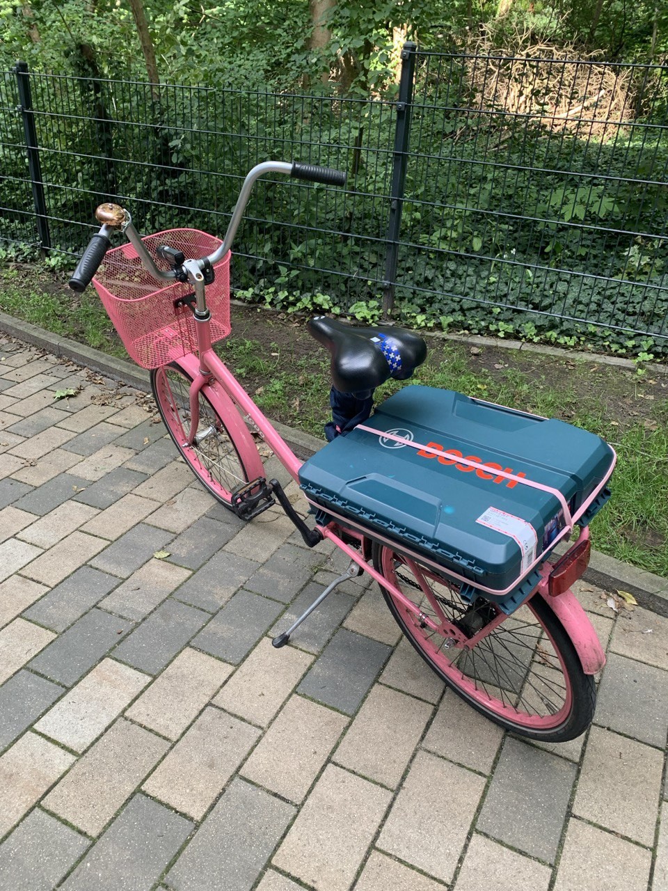 Mein Fahrrad: Ein pinkes Jopo-Fahrrad von Helkama mit pinken Reifen, einem pinken Korb und einer bronzefarbenen Fahrradklingel. Der jopo-Schriftzug ist weiß.